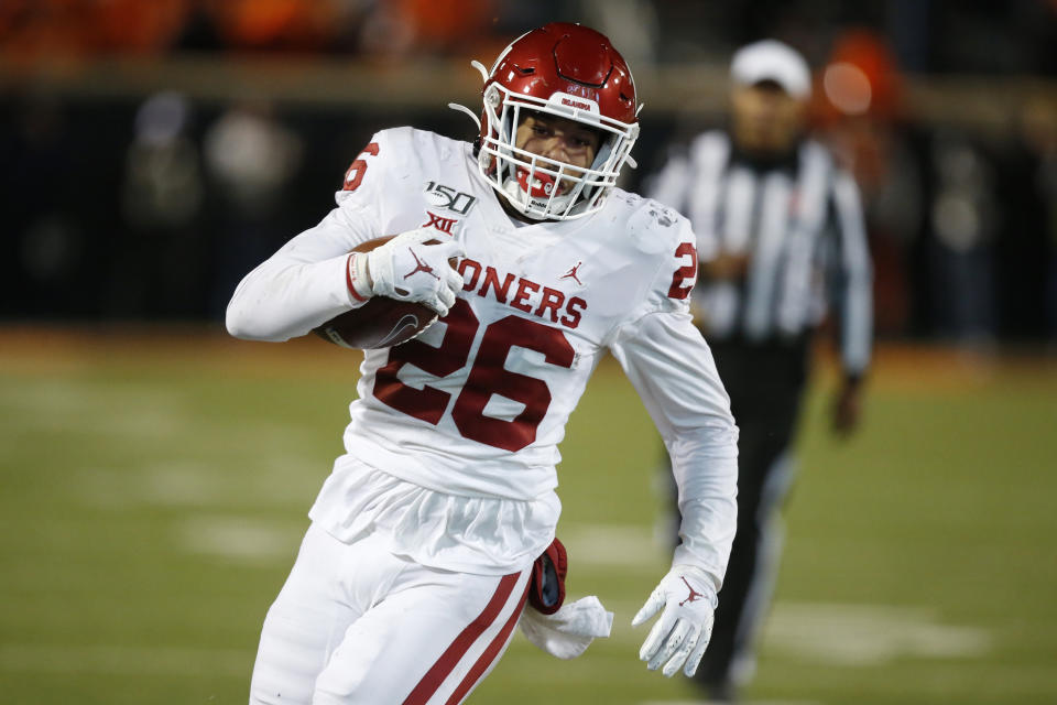 FILE - Oklahoma running back Kennedy Brooks (26) carries during an NCAA college football game against Oklahoma State in Stillwater, Okla., in this Saturday, Nov. 30, 2019, file photo. Most of the top college football players who opted out of the 2020 season due to the pandemic decided to leave school and launch their pro careers. But plenty of other players who opted out of last season chose to continue their college careers either at their original school or opted to transfer. The list of notable players back this season after opting out last year features two-time, 1,000-yard rusher Kennedy Brooks of Oklahoma.(AP Photo/Sue Ogrocki, File)