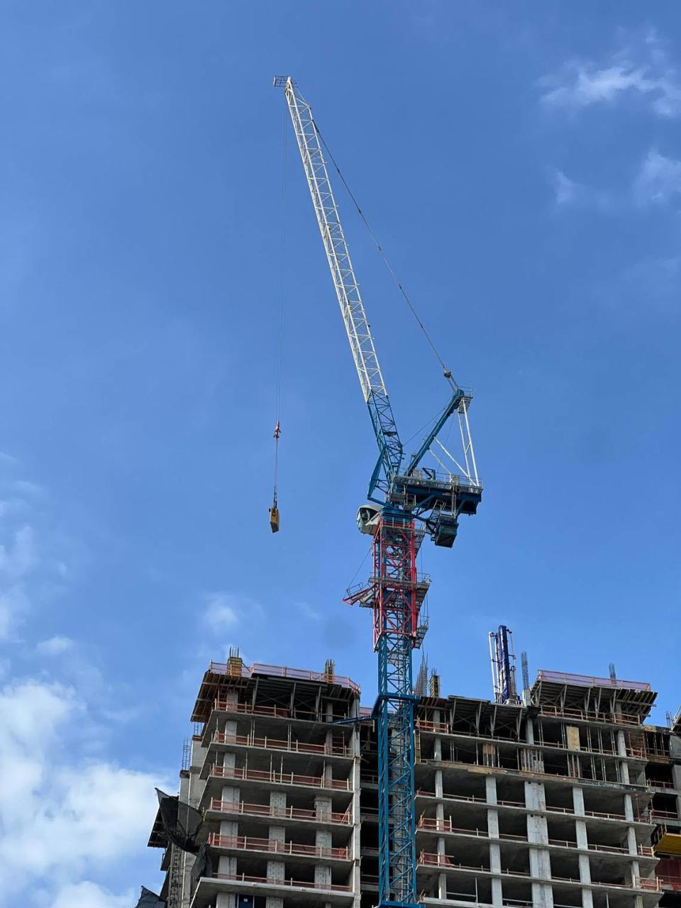 A damaged crane sits atop a tower next to a building under construction at Southeast 3rd Avenue in Fort Lauderdale Thursday, April 4, 2024.