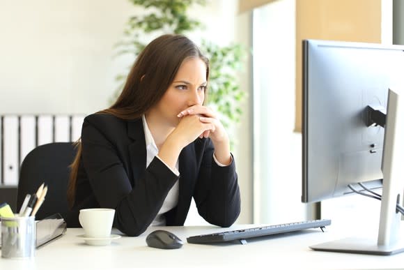 Woman in suit jacket looking at computer screen