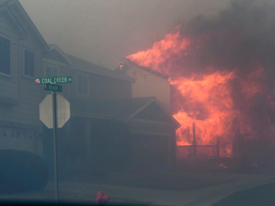 A house ablaze in Colorado, caused by forest fires.