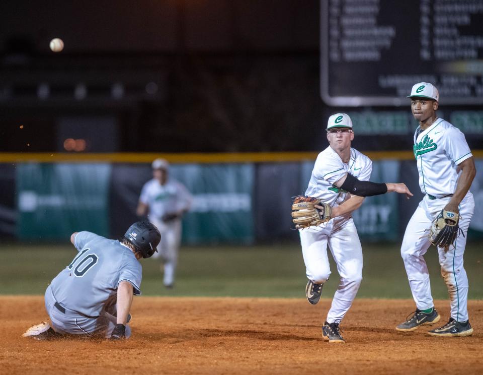 Shortstop Colton Guillot (19) throws to first to turn a double play during the South Walton vs Catholic baseball game at Pensacola Catholic High School on Friday, March 24, 2023.