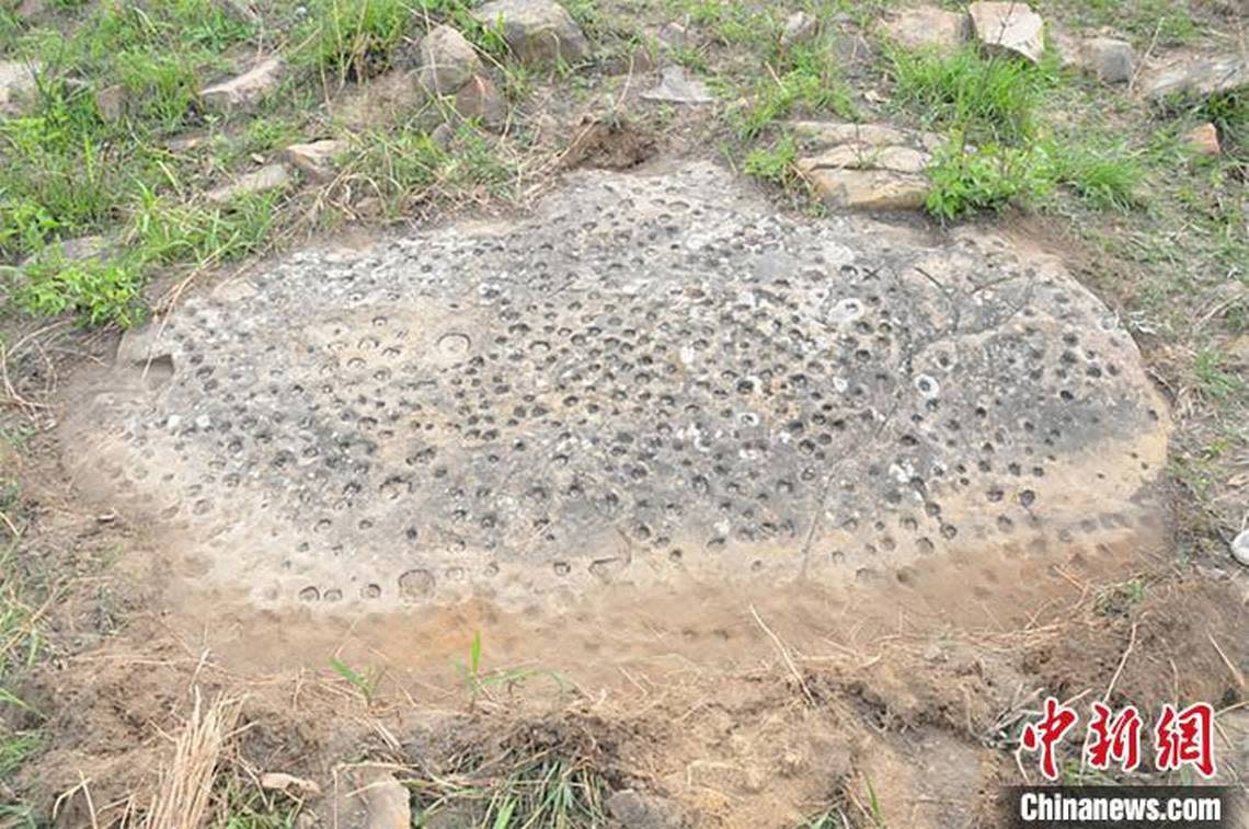 A rock carving with a design of dense dots.