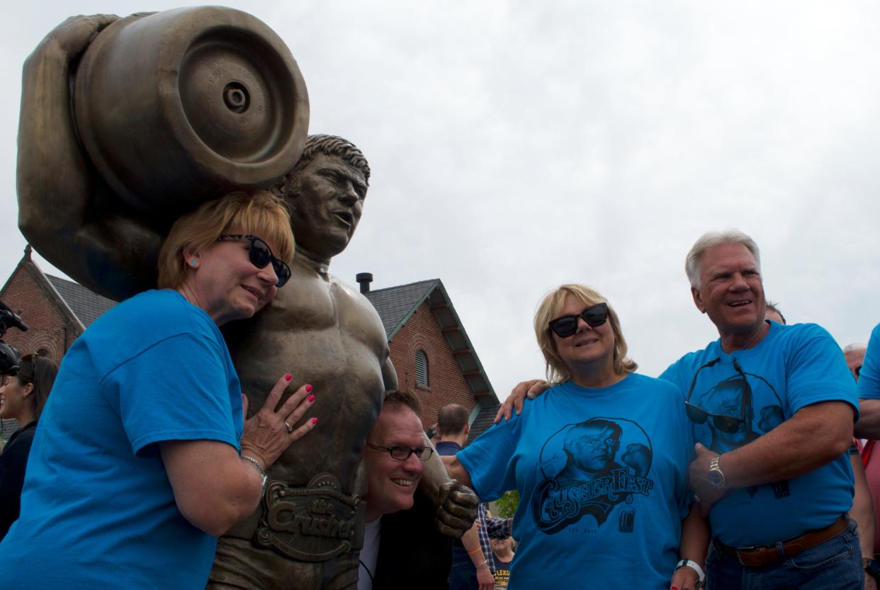 Family members and South Milwaukee's former mayor pose with the statue of Reggie "Da Crusher" Lisowski at Crusherfest on June 8, 2019. Pictured are (from left) Sherri Brozoski, former Mayor Erik Brooks, Dawn Lisowski and Larry Lisowski.