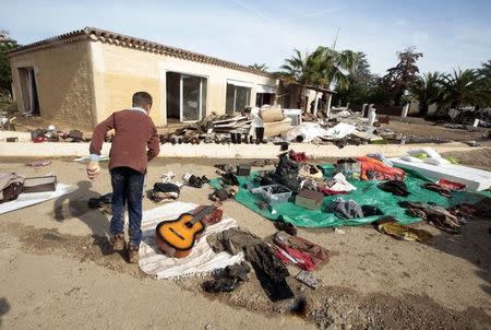 A boy walks past belongings put out to dry in front of his home after flooding caused by torrential rain in Biot, France, October 4, 2015. REUTERS/Eric Gaillard