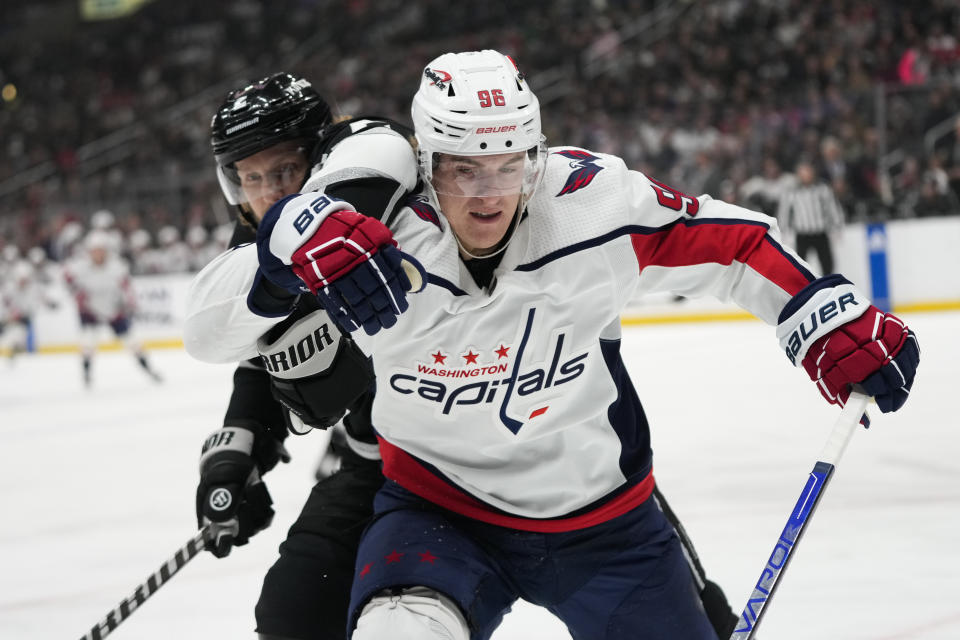 Washington Capitals' Nicolas Aube-Kubel (96) and Los Angeles Kings' Alexander Edler (2) are tangled up as they chase the puck during the first period of an NHL hockey game Monday, March 6, 2023, in Los Angeles. (AP Photo/Jae C. Hong)