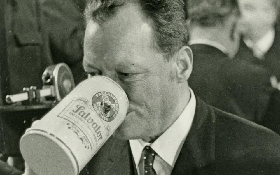 Sie kamen alle gerne nach München, die Großen der Bundesrepublik. Willy Brandt, ganz im korrekten Zweireiher-Stil der 60er-Jahre, genehmigte sich bereits 1966 einen herzhaften Schluck aus dem Maßkrug - drei Jahre später wurde der SPD-Mann Bundeskanzler. Im Sommer 1966 wurde der damalige SPD-Chef bereits Außenminister und Vizekanzler. (Bild: Paulaner / Bayerisches Wirtschaftsarchiv)