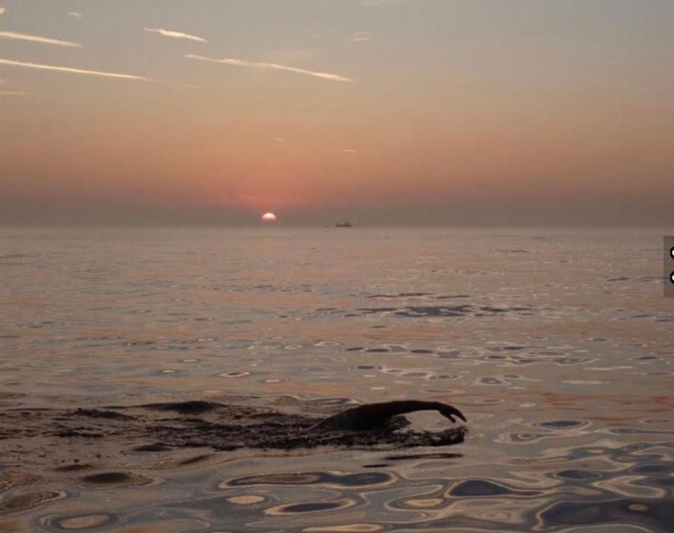 As the sun sets on the English horizon, Sarasota's Allen 
Hillman swims the 21 miles across tne English Channel.