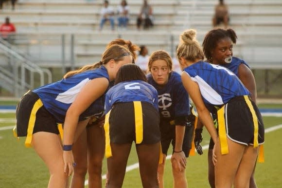 The Tuscaloosa County girls flag football team huddles with quarterback Macy Hudgins and wide receiver Breona Walker