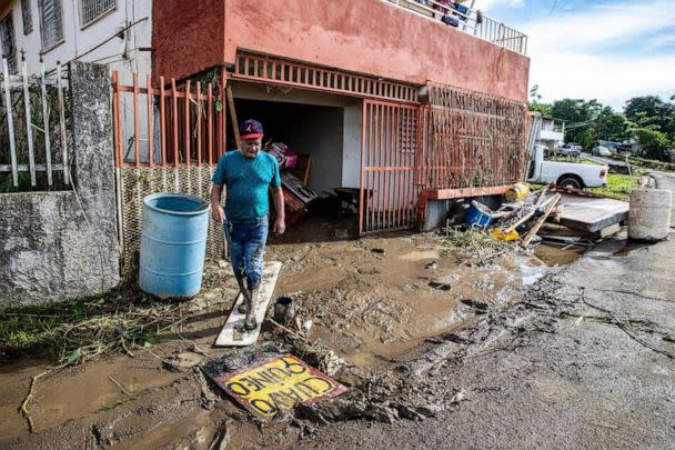 PHOTO: A man walks out of his house through the mud left by the river Rio de la Plata overflowing in the San Jose de Toa Baja, on Sept. 20, 2022, after Hurricane Fiona passed by Puerto Rico. (Pedro Portal/TNS via Newscom)