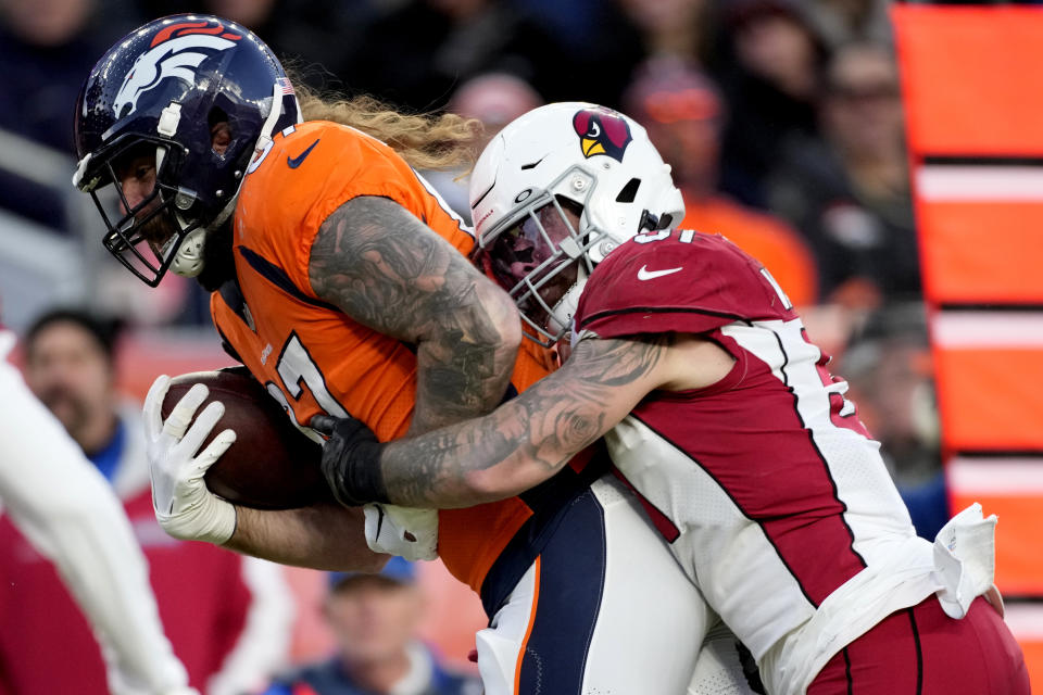 Denver Broncos tight end Eric Tomlinson (87) is hit by Arizona Cardinals linebacker Tanner Vallejo during the second half of an NFL football game, Sunday, Dec. 18, 2022, in Denver. (AP Photo/David Zalubowski)