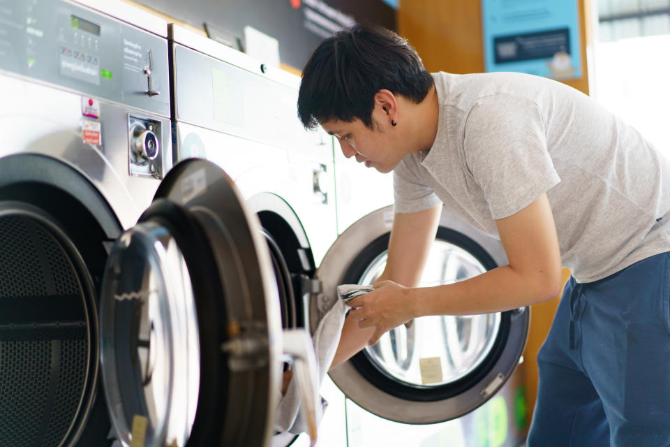 someone doing their laundry at a laundromat