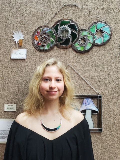 Rachel Lamb, a co-winner of a countywide high school art contest, poses with her work.