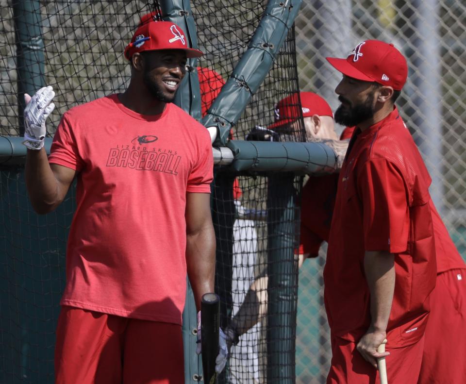 Dexter Fowler (left) talks with Matt Carpenter during a Cardinals spring training workout. (AP)