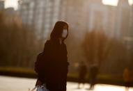 A woman wears a face mask outside an office complex in Beijing as the country is hit by an outbreak of the novel coronavirus