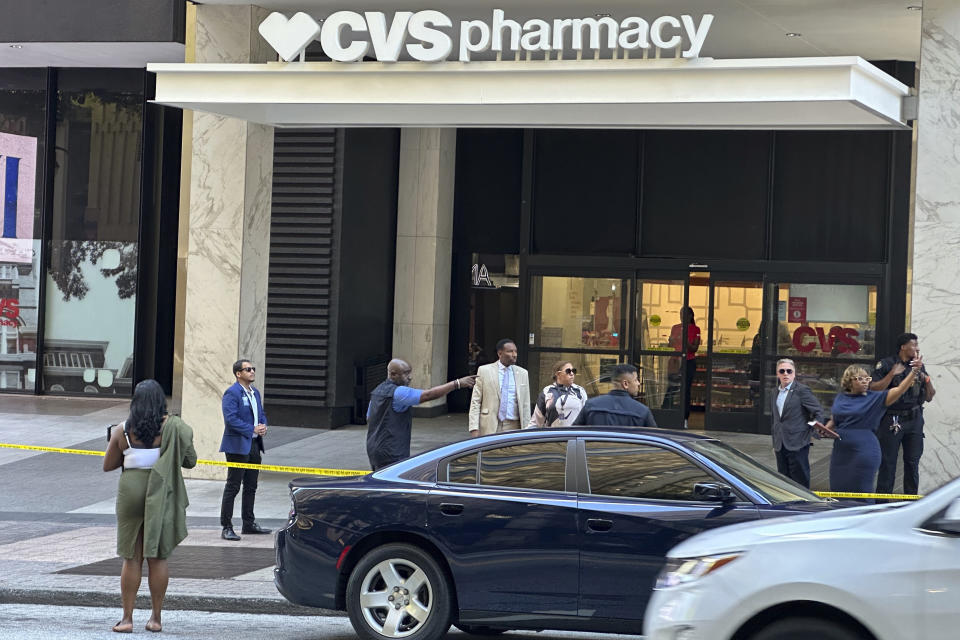 Atlanta Mayor Andre Dickens, in tan suit, arrives at the scene of a shooting outside the Peachtree Center complex, Tuesday, June 11, 2024, in downtown Atlanta. (AP Photo/Jeff Amy)