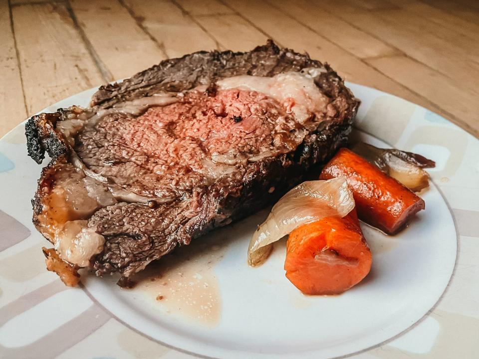 slice of prime rib roast with tomatoes and onions