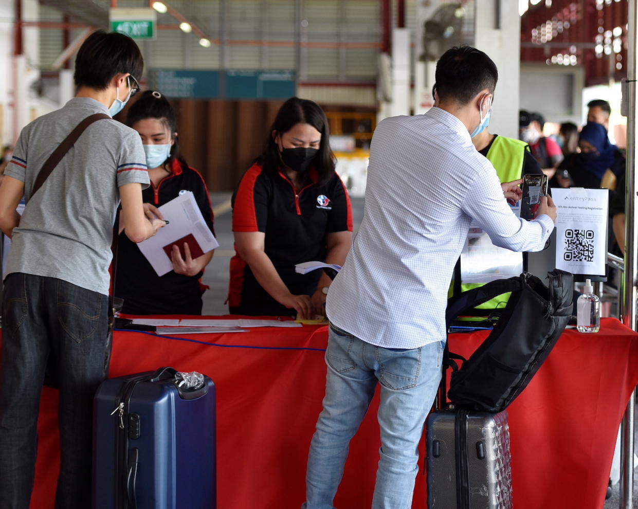 People wait to board a bus in Singapore back to Malaysia, as the Vaccinated Travel Lane between the two countries opened on 29 November 2021. (PHOTO: Reuters)