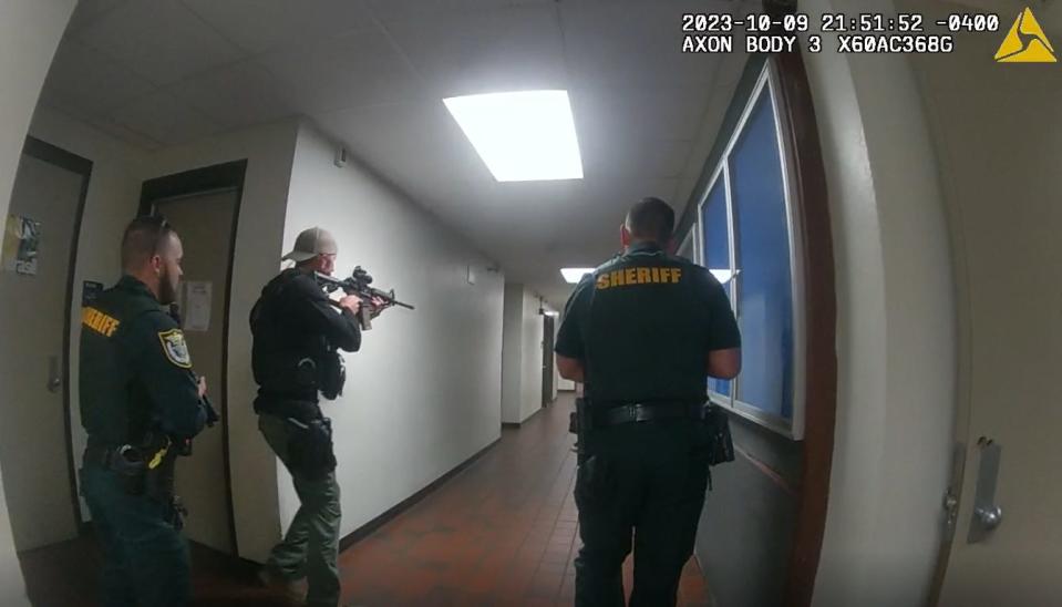 Unidentified Alachua County Sheriff's Office deputies, armed with assault rifles and pistols, are seen in newly released police body camera video searching the University of Florida Turlington Hall classroom building Oct. 9, 2023, after a a panicked stampede during a nighttime vigil on campus for Israelis killed in Hamas attacks.