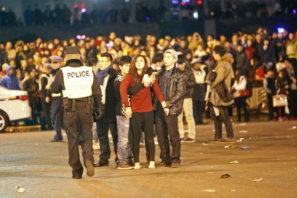 A man holds a woman after a stampede during a New Year's celebration on the Bund, central Shanghai