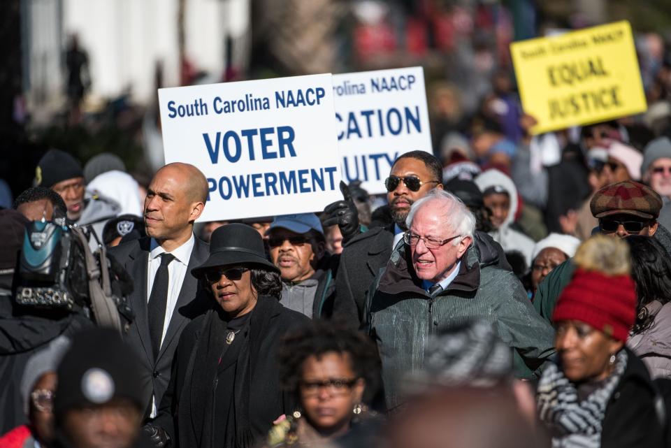 Sen. Bernie Sanders; Brenda Murphy, president of the South Carolina NAACP chapter; and Sen. Cory Booker march down Main Street to the Statehouse in commemoration of Martin Luther King Jr. Day in Columbia, S.C.