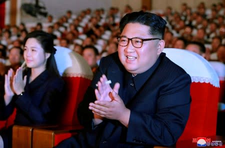 North Korean leader Kim Jong Un and his wife Ri Sol Ju watch a performance given by amateur art groups of the wives of officers of units of the Korean People's Army