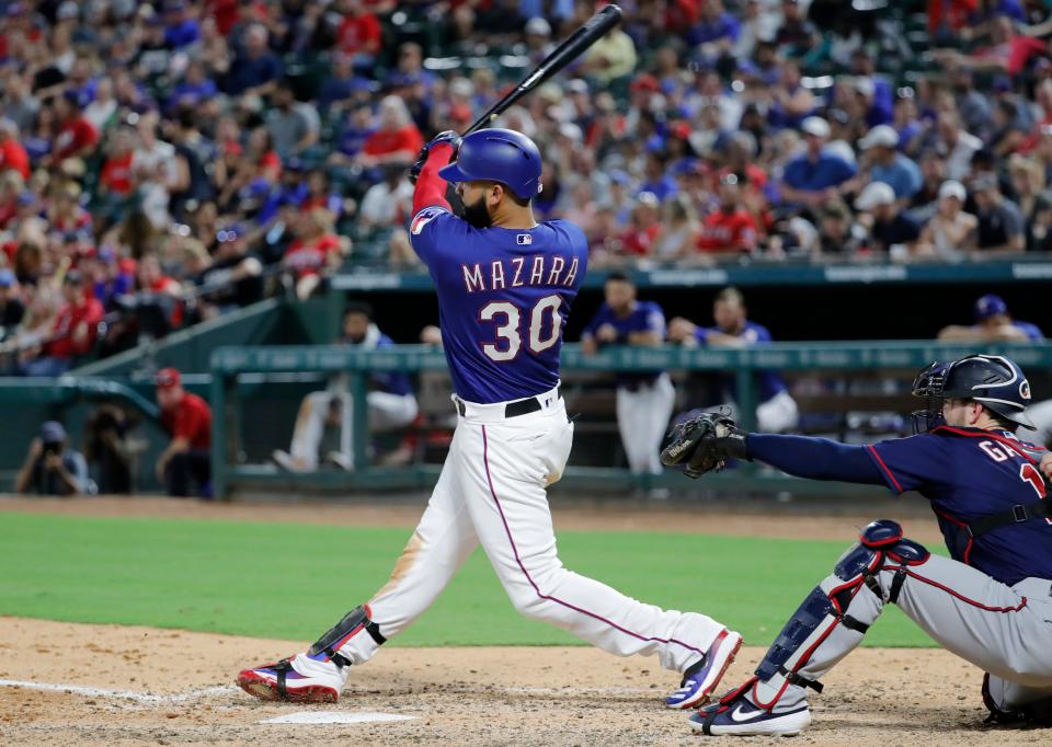 Texas Rangers' Nomar Mazara follows through on a two-run double off Minnesota Twins' Jake Odorizzi as catcher Mitch Garver watches during the sixth inning of a baseball game in Arlington, Texas, Friday, Aug. 16, 2019. (AP Photo/Tony Gutierrez)