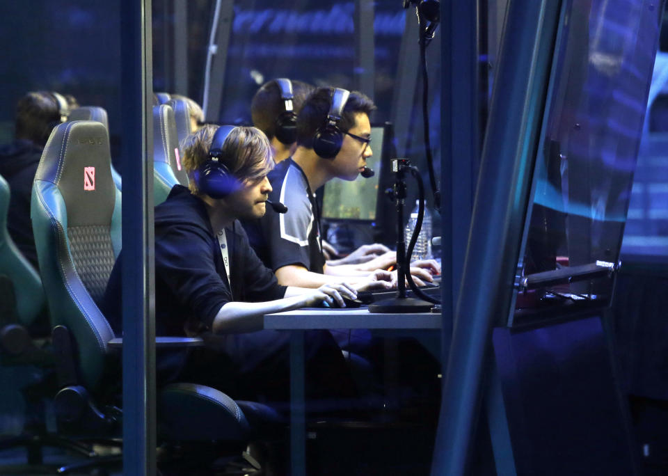 Members of team OG sit inside glass-enclosed rooms as they play a match during the International Dota 2 Championships Wednesday, Aug. 9, 2017, in Seattle. Members of the five-person eSport teams each select fantasy-world hero characters and the teams then face off for control of the game world's map. The championship, pitting 16 teams against each other for $24 million in prize money, runs through Saturday. (AP Photo/Elaine Thompson)