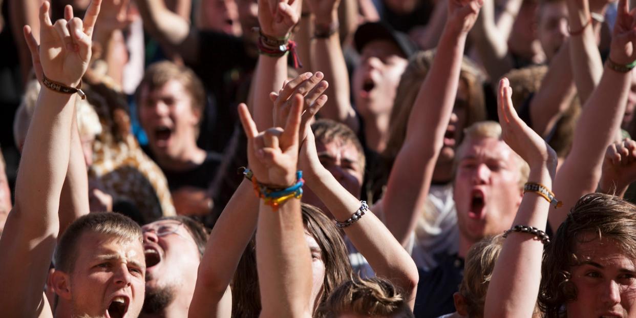 A crowd of festival-goers, arms in the air, at Roskilde, Denmark, 2012.