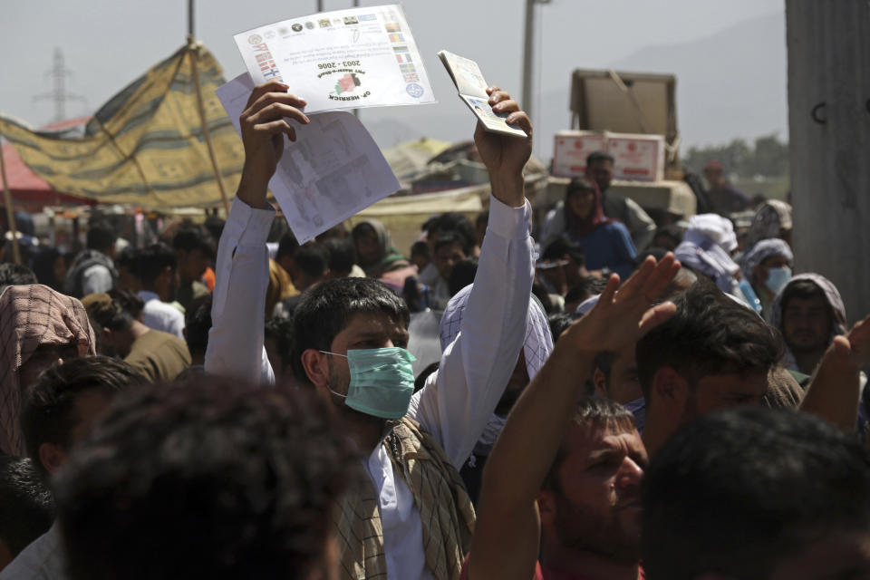 FILE - In this Aug. 26, 2021, file photo, hundreds of people gather, some holding documents, near an evacuation control checkpoint on the perimeter of the Hamid Karzai International Airport, in Kabul, Afghanistan. Many U.S. citizens and green card holders are still in the Afghan capital despite official promises that every American who wants to leave Afghanistan would be taken out. (AP Photo/Wali Sabawoon, File)