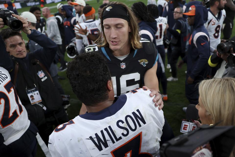 Jacksonville Jaguars quarterback Trevor Lawrence (16) and Denver Broncos quarterback Russell Wilson (3) chat after the NFL football game between Denver Broncos and Jacksonville Jaguars at Wembley Stadium in London, Sunday, Oct. 30, 2022. Denver Broncos won by 21-17.(AP Photo/Ian Walton)