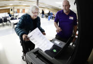 Linda Schwartzbauer inserts her ballot into the voting machine as election volunteer Jeff Rotering watches at the Mandan Eagles Club in Mandan, North Dakota, Tuesday, Nov. 8, 2022. (Mike McCleary/The Bismarck Tribune via AP)