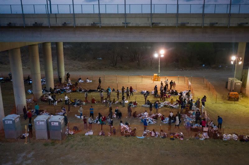 Migrant families and unaccompanied minors take refuge at a processing center under Anzalduas International Bridge in Granjeno, Texas