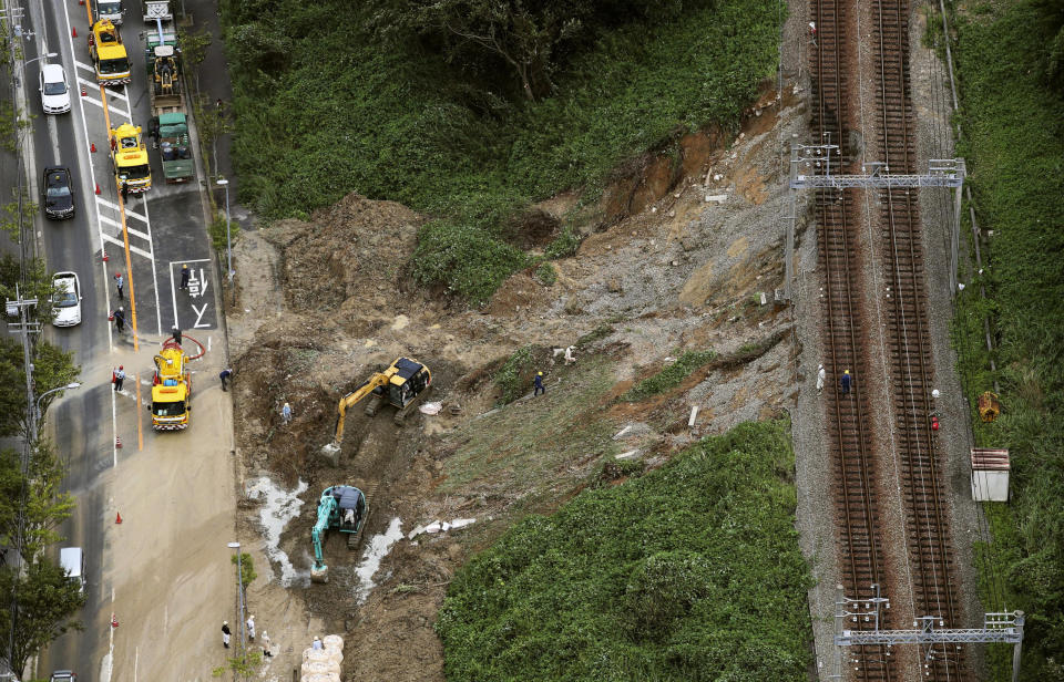 A landslide site is seen near railroad tracks after Typhoon Cimarron hit the area in Kobe, western Japan Friday Aug. 24, 2018. Typhoon Cimarron was back at sea and heading for northern Japan after crossing a swath of the western part of the country overnight, bringing heavy rain and high winds. (Kyodo News via AP)