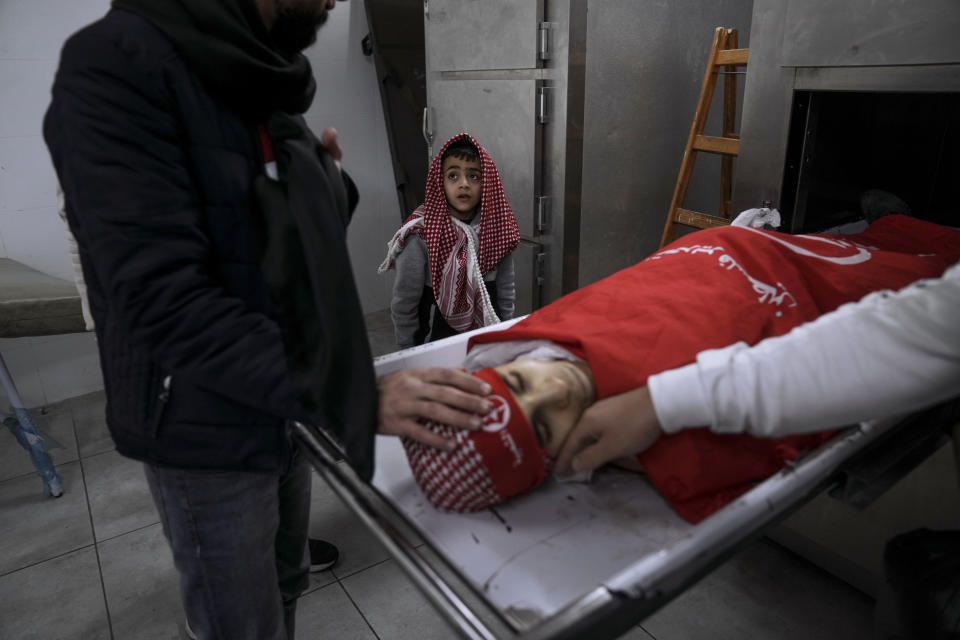 Relatives of 15-year-old Palestinian Adam Ayyad, take a last look at his body in the morgue, just before his funeral in the West Bank city of Bethlehem, Tuesday, Jan. 3, 2023. The Palestinian Health Ministry said Ayyad died of a bullet wound to the chest. The Israeli military said Border Police officers came under attack in the Dheisha refugee camp next to Bethlehem. It said troops shot at people throwing firebombs and confirmed that a person was shot. (AP Photo/Mahmoud Illean)