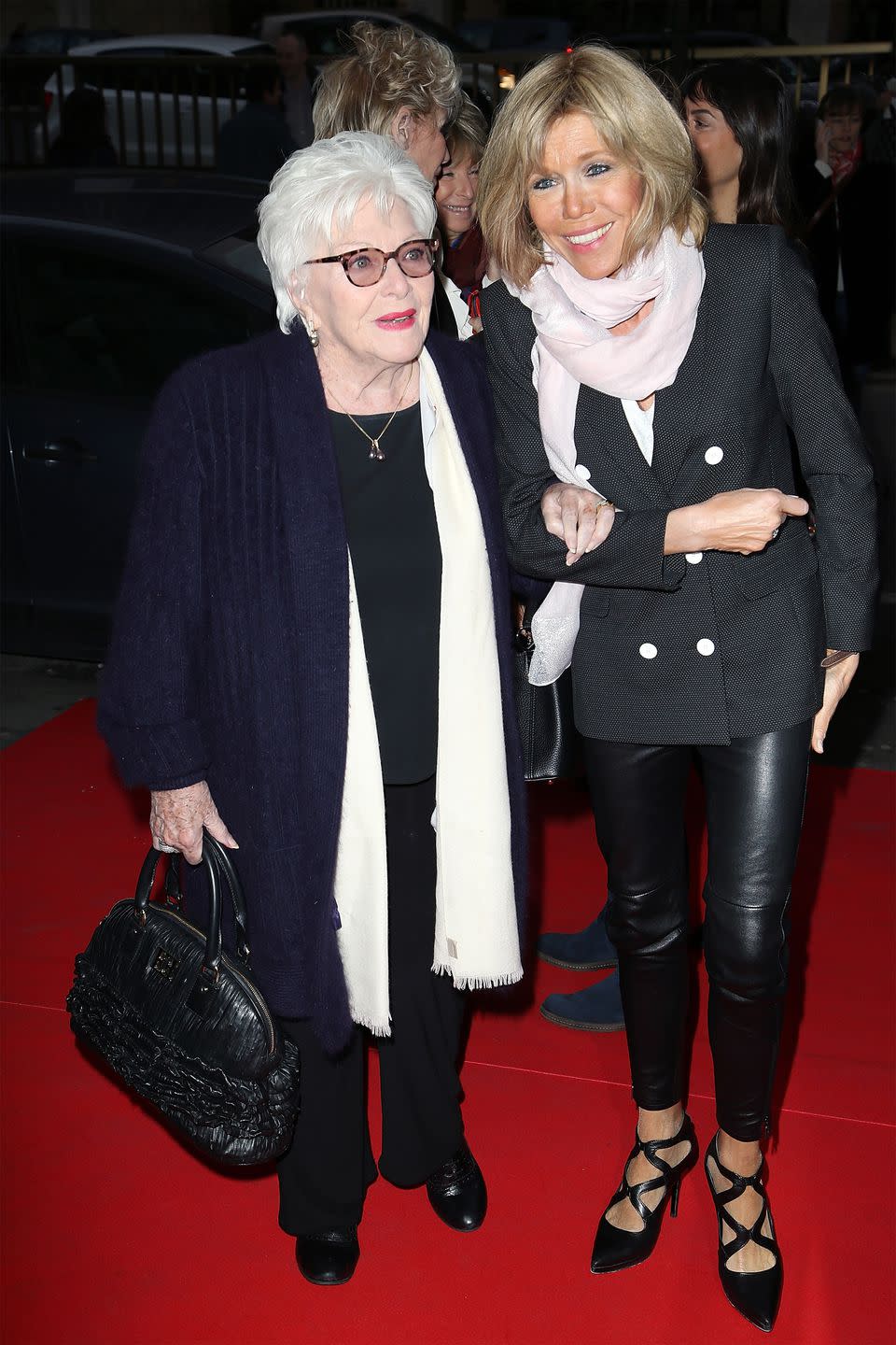 <p>Wearing a double-breasted blazer and pink scarf with leather pants and pointed-toe heels with Line Renaud at a premiere in Paris, France.</p>