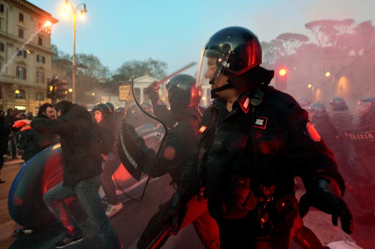 People clash with riot police in Piazza del Popolo, downtown Rome on February 27, 2015