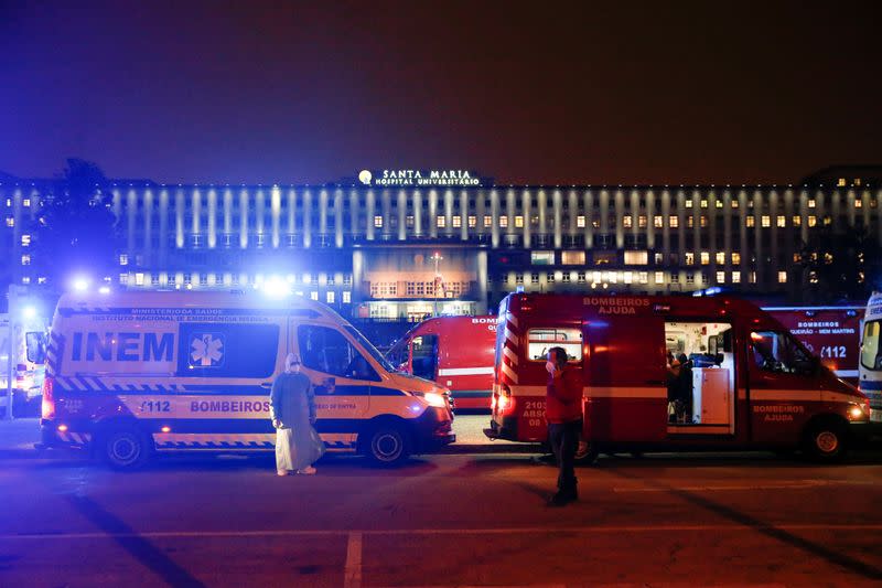 FILE PHOTO: Medical personnel stand next to ambulances with COVID-19 patients as they wait in the queue at Santa Maria hospital, amid the coronavirus disease (COVID-19) pandemic in Lisbon