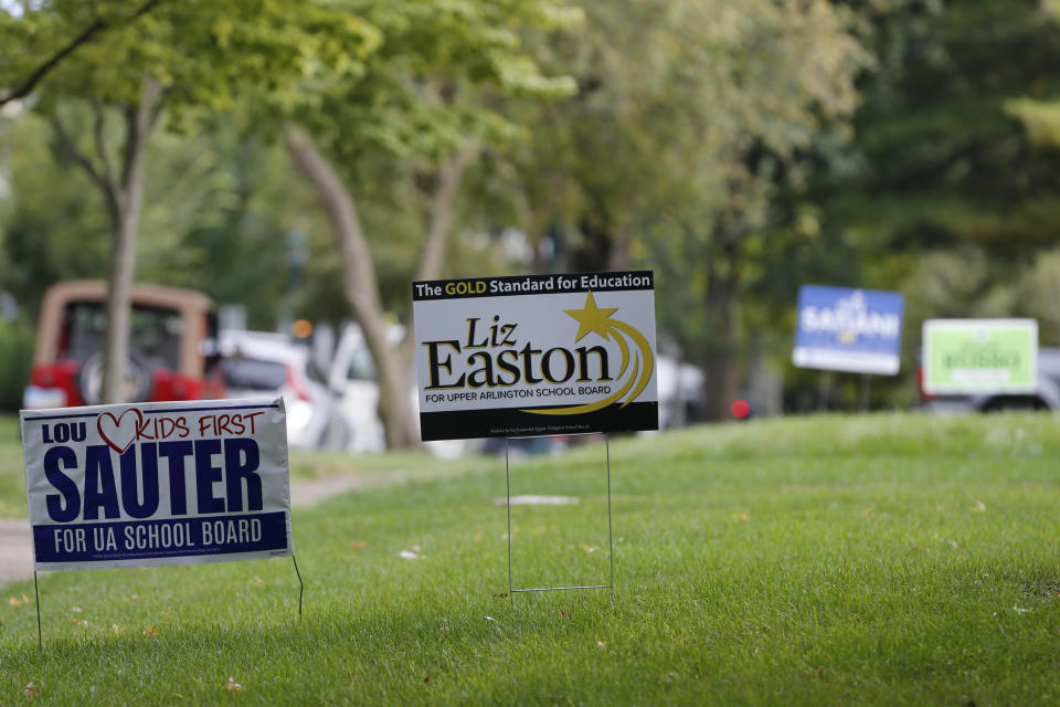 Campaign yard signs line a street Thursday, Oct. 7, 2021, in Upper Arlington, Ohio. Across Ohio and the nation, parental protests over social issues like mask mandates, gender-neutral bathrooms, teachings on racial history, sexuality and mental and emotional health are being leveraged into school board takeover campaigns. (AP Photo/Jay LaPrete)