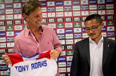 Former Arsenal and England captain Tony Adams holds Granada's jersey next to the club's vice-president Kangning Wang after being presented as the new head coach in Granada, Spain April 11, 2017. REUTERS/Pepe Marin
