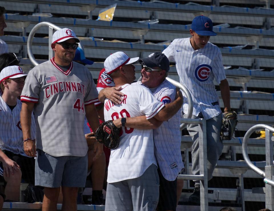 A Chicago Cubs fan hugs a Cincinnati Reds fan at the Field of Dreams stadium in Dyersville prior to the start of a Major League Baseball game between the Cubs and Reds on Thursday, Aug. 11, 2022.