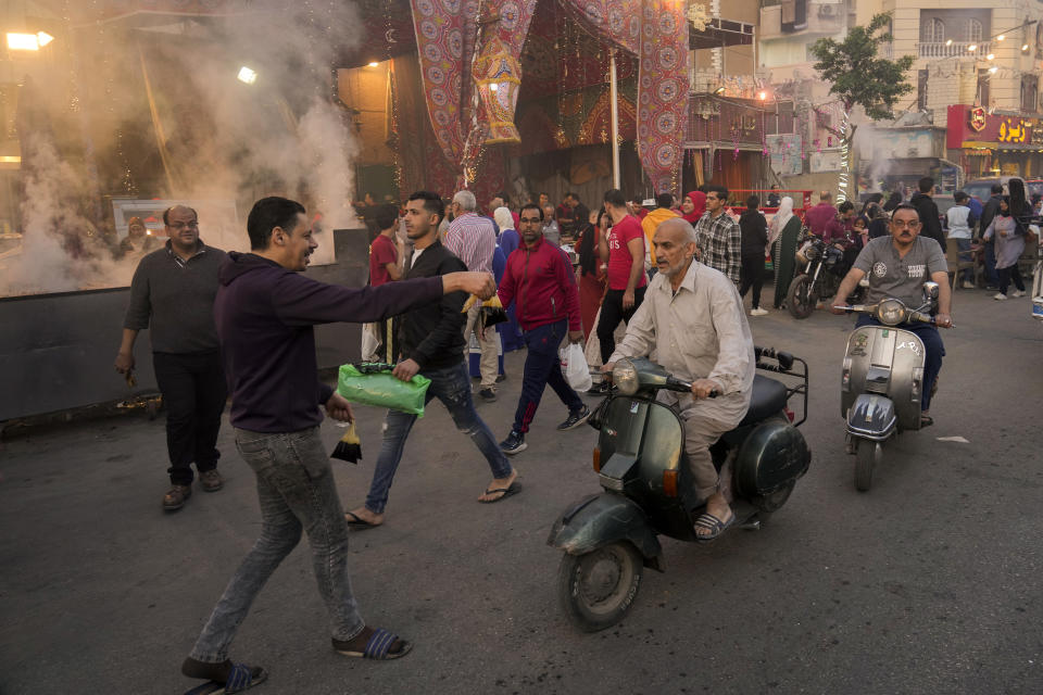 FILE - A volunteer distributes free juice ahead of Iftar, the evening meal breaking the Ramadan fast, at El-Gamaliyya district in Cairo, Egypt Friday, April 14, 2023. (AP Photo/Amr Nabil, File)