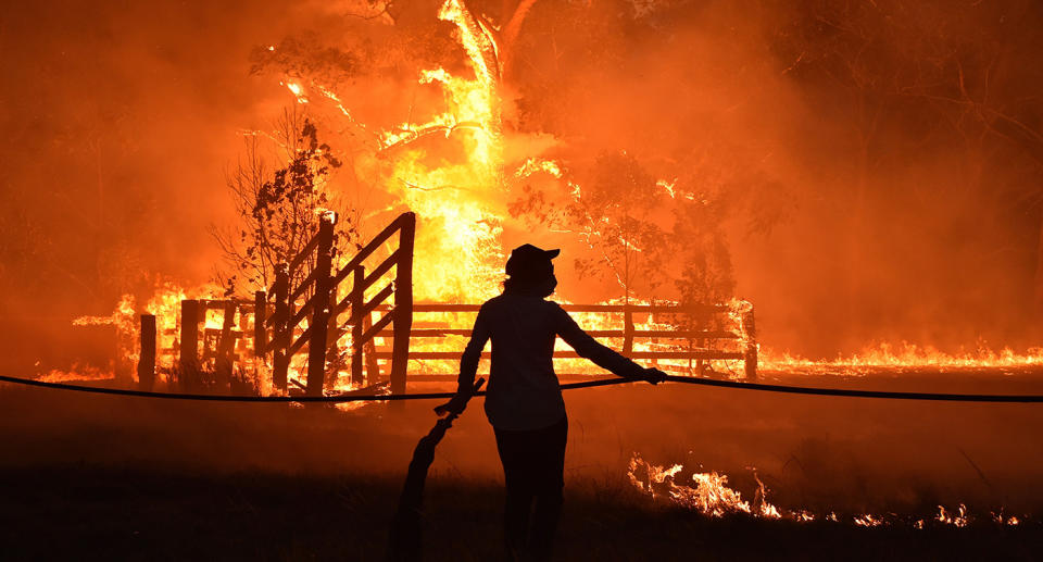 Residents defend a property from a bushfire at Hillsville near Taree, 350km north of Sydney. Source: Getty Images