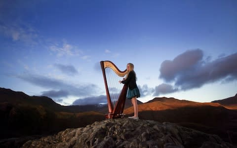 Craftsman Create Traditional Harps...CAPEL CURIG, UNITED KINGDOM - NOVEMBER 16: Harpist Hero Melia, aged eleven, poses with her Pilgrim Harp in the mountains of Snowdonia on November 16, 2010 in Capel Curig, United Kingdom. Hero was spotted on television by the craftsmen of Pilgrim Harps, in Surrey, England and they are giving her a handmade and personalised harp by the instrument artists. The small dedicated team work in a converted coach house creating the classical instruments with intricate details carved by hand. (Photo by Christopher Furlong/Getty Images) - Credit: Christopher Furlong/Getty Images