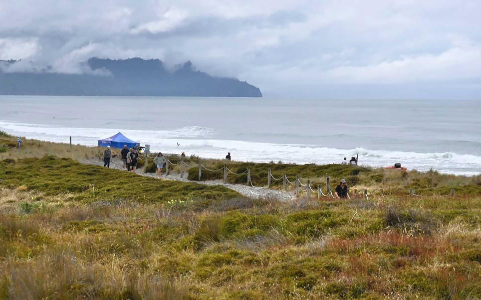 People walk near a beach following a shark attack at Bowentown near Waihi in New Zealand, Friday, Jan 8, 2021. A woman has died Thursday, Jan. 7, in what appears to be New Zealand's first fatal shark attack in eight years, police say. (George Novak/Bay of Plenty Times via AP)