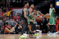 Boston Celtics forward Aaron Nesmith, right, bumps back Houston Rockets center Christian Wood (35) as he looks to drive to the basket during the first half of an NBA basketball game, Sunday, Oct. 24, 2021, in Houston. (AP Photo/Michael Wyke)