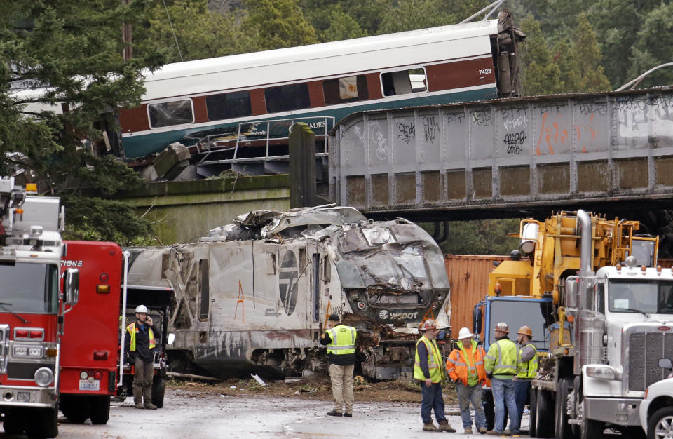 <p>Cars from an Amtrak train lay spilled onto Interstate 5 below as some train cars remain on the tracks above Monday, Dec. 18, 2017, in DuPont, Wash. (Photo: Elaine Thompson/AP) </p>