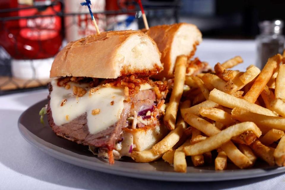 The KC Queen: 12-hour smoked brisket, sliced thick, topped with melted American cheese, housemade BBQ sauce, slaw and crispy onion straws piled into a French roll.