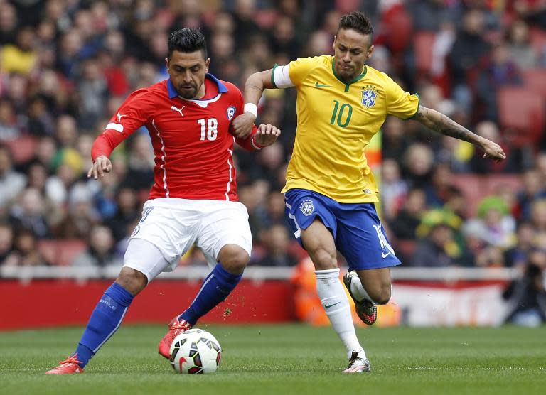 Brazilian striker Neymar challenges Chile's defender Gonzalo Jara (L), showing the steely determination that helped Brazil win the friendly match on March 29, 2015