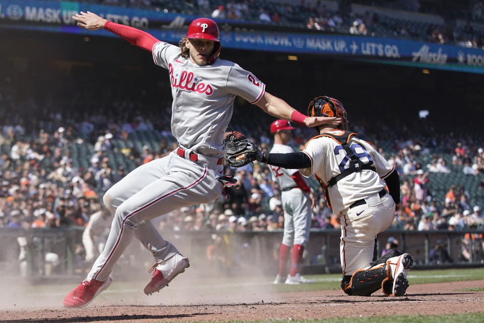 Philadelphia Phillies' Alec Bohm, left, scores past San Francisco Giants catcher Buster Posey during the seventh inning of a baseball game in San Francisco, Saturday, June 19, 2021. (AP Photo/Jeff Chiu)