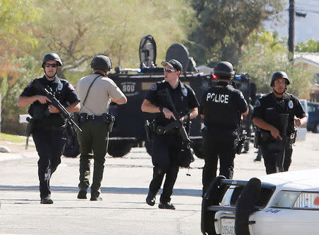 Armed police officers are shown during a standoff where three officers were shot by a suspect in Palm Springs, California, U.S. October 8, 2016. REUTERS/Sam Mircovich